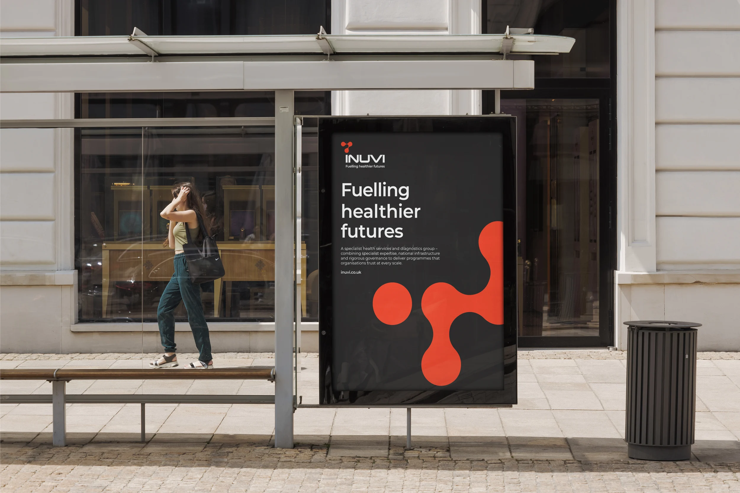 Inuvi ‘Fuelling healthier futures’ poster at a bus stop, with the red molecular shape on a dark grey background