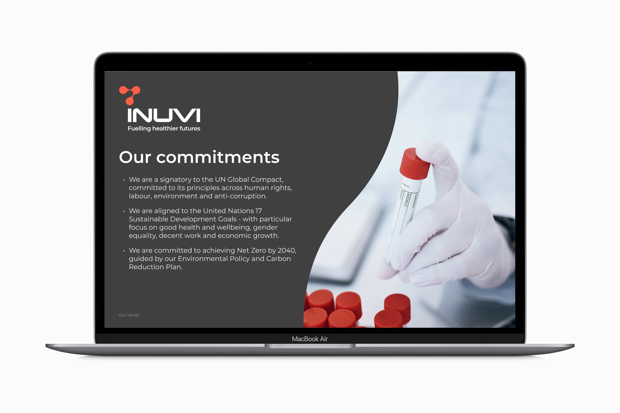 Inuvi slide deck on a laptop: an ‘Our commitments’ slide on dark grey, with a gloved hand holding a red-capped sample tube inside the curved frame