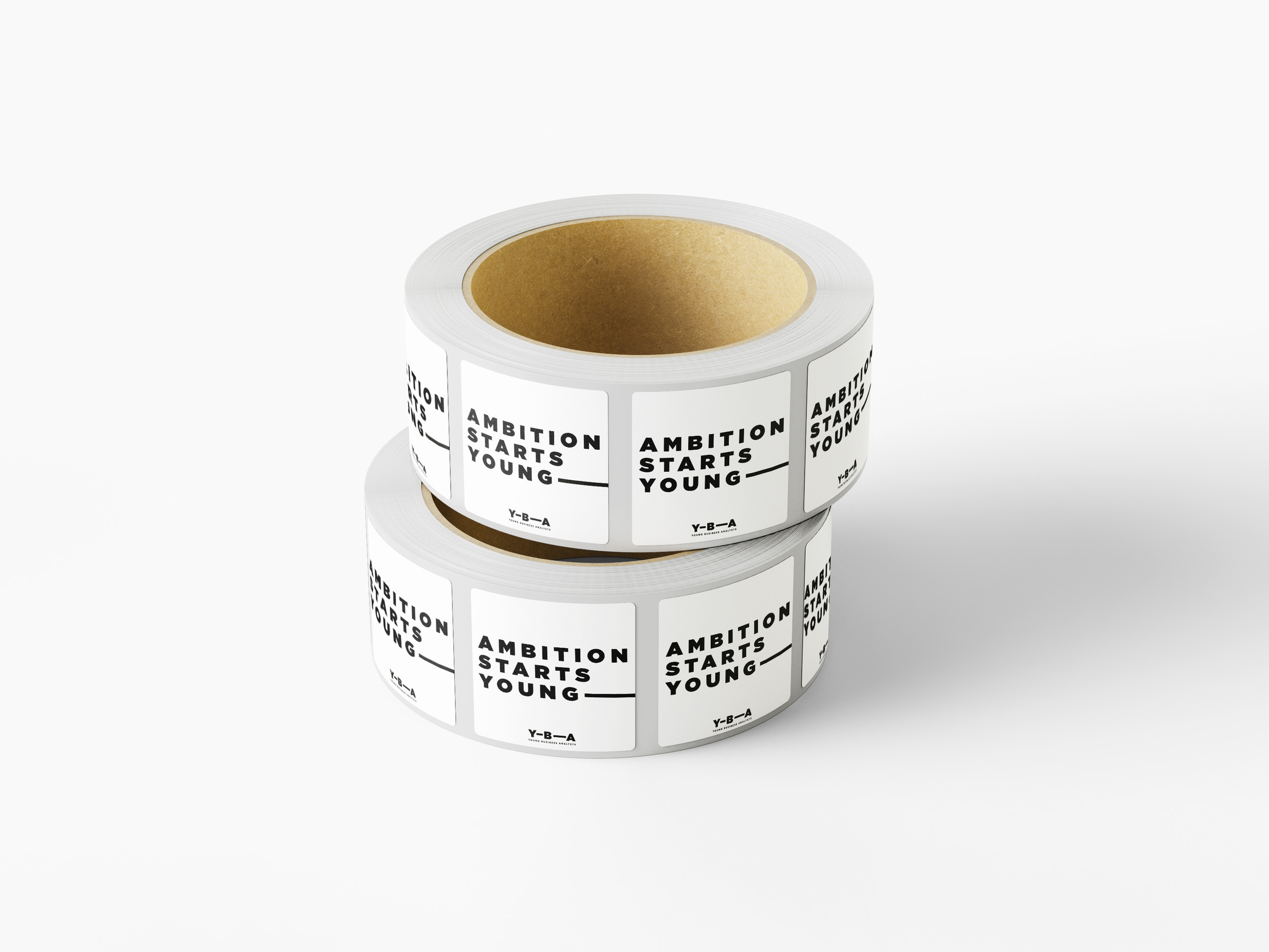 Two stacked rolls of square YBA stickers reading ‘Ambition starts young’ with the extending line and the YBA logo